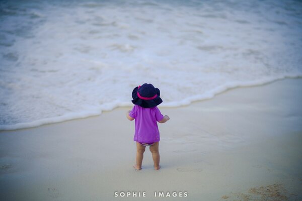 A child in lilac on a sandy beach