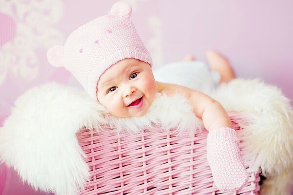 Un niño pequeño en una cesta rosa