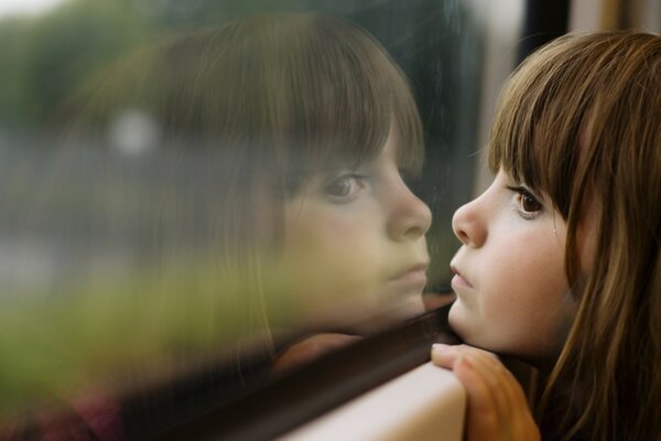 The child looks in the reflection window