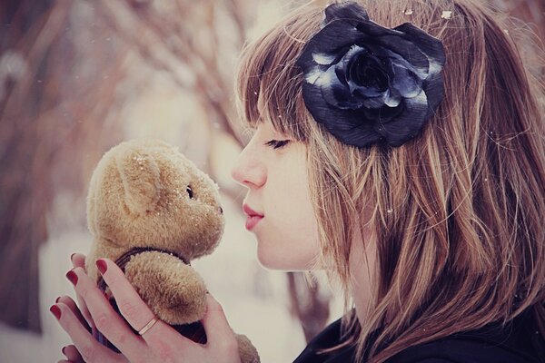 Girl kisses a teddy bear