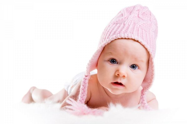 Un bambino piccolo in un berretto giace