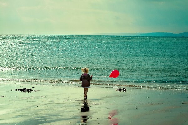 A girl with a balloon on the background of the sea