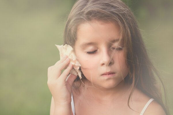 A child listens to the sounds of the sea