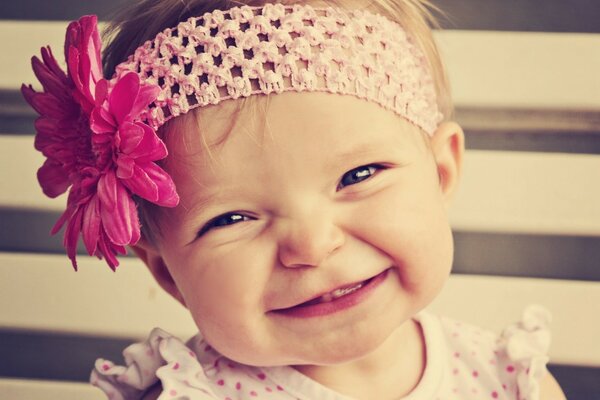 Petite fille dans un bandage avec une fleur. Portrait