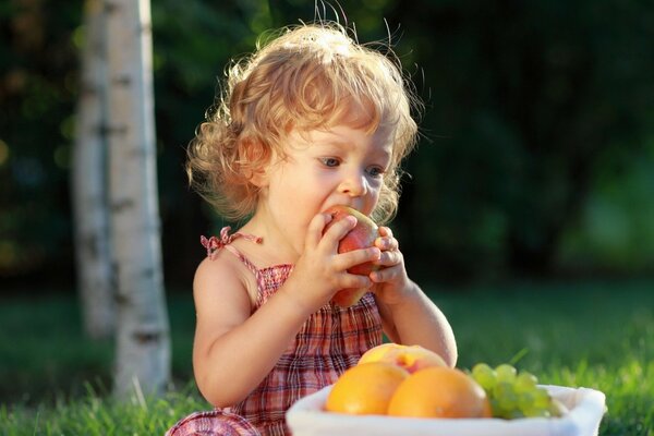 Enfant mange des fruits dans la nature