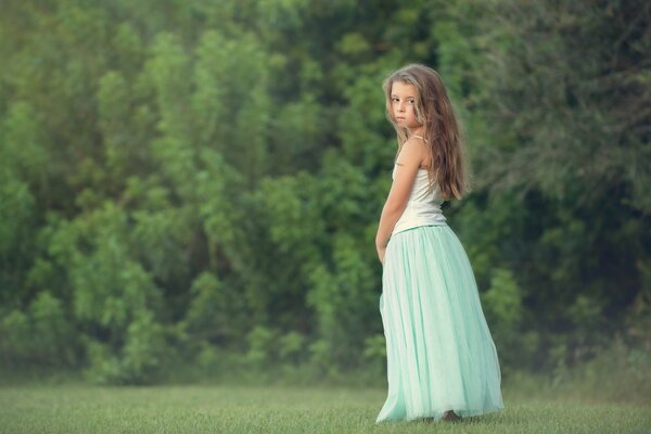 Bella ragazza su sfondo foresta in gonna lunga