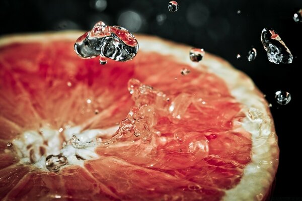 Macro photography of falling drops on a cut fruit