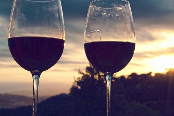 Dos copas de vino contra un cielo nublado