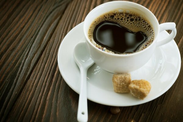 Café noir dans une tasse blanche et sucre