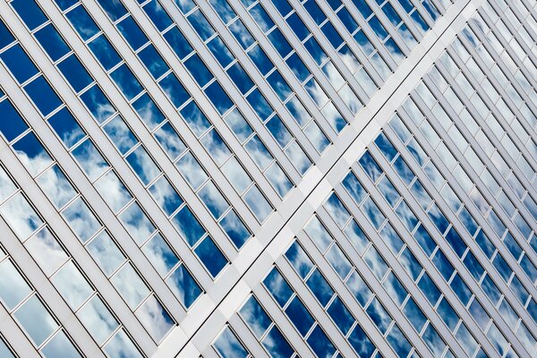 Reflejo escénico del cielo en las ventanas de un edificio de varios pisos