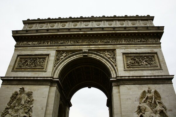 Grey monument with arch and bas-reliefs