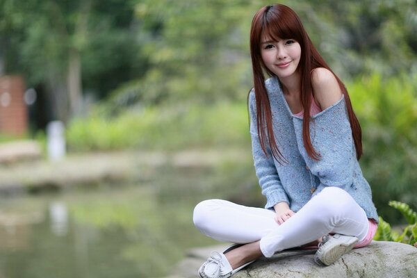 A girl with long hair is relaxing outdoors