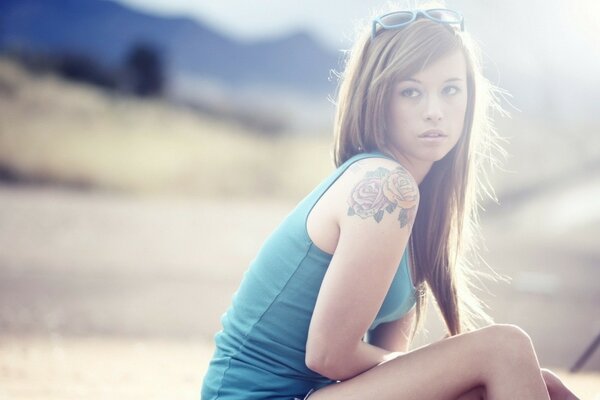 Fille en haut bleu assis sur la plage