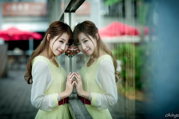 A girl poses on the street at a shop window