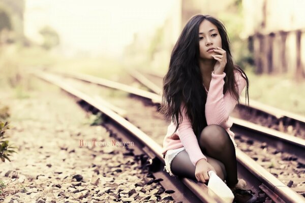 Chica posando en la pista del tren chica con sombrero de paja en el Prado