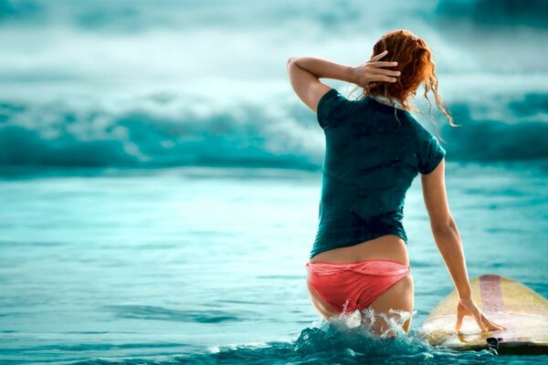 La surfeuse avec une planche jaune est sortie à l entraînement