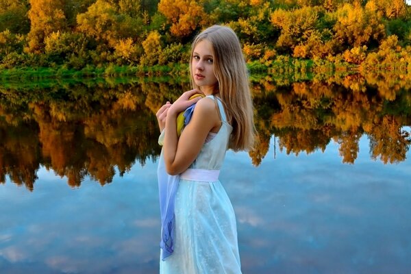 Chica en el fondo del paisaje de otoño