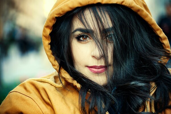 A brunette girl in a yellow jacket