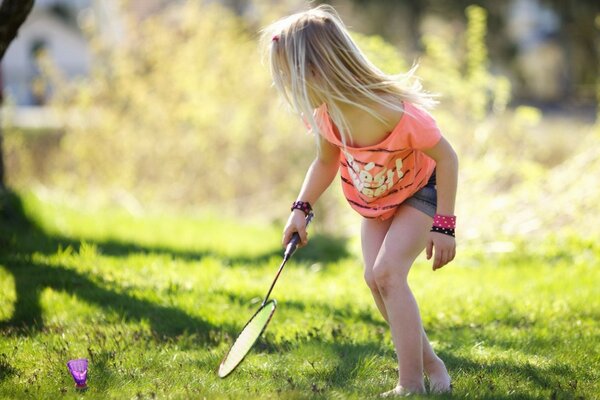 A girl plays badminton in the summer outdoors