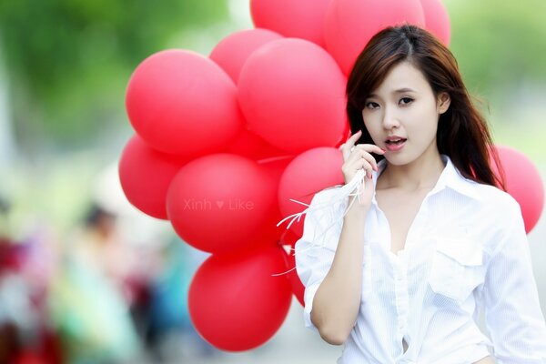 Fille en blanc avec des boules rouges