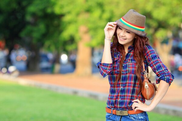 Portrait of a girl in a hat in nature in summer