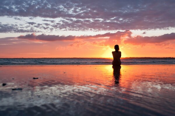 Silueta de una mujer al amanecer en el agua