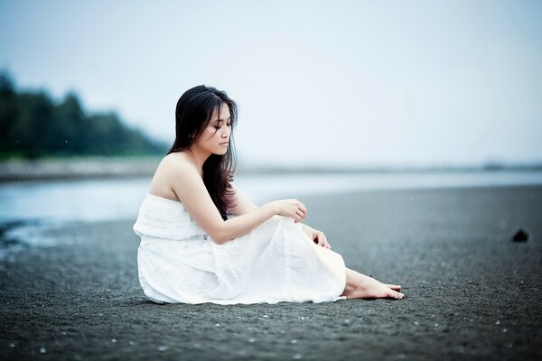 A girl in a white dress on the beach