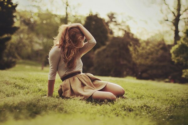 A girl sitting on the grass in nature