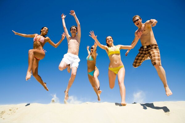 Divertimento sulla spiaggia di cinque persone