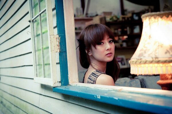 A young girl looks out the window