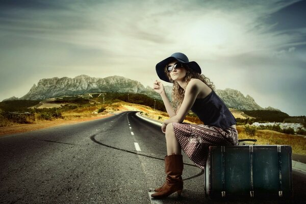 Hitchhiking. A girl in a hat on the road