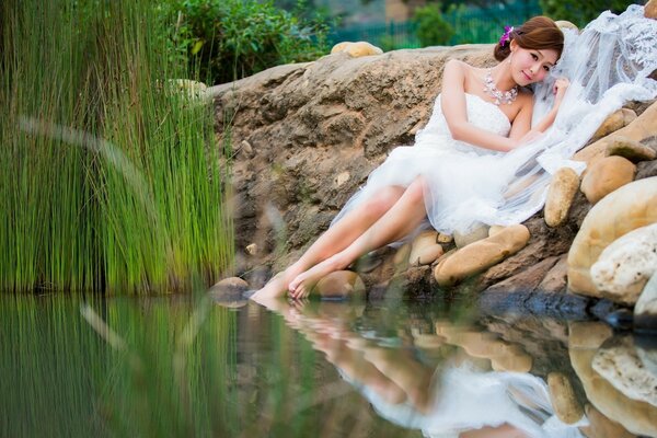 Femme en robe blanche se trouve près d un plan d eau