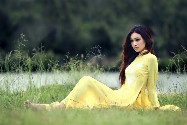 A girl in a light yellow dress in nature