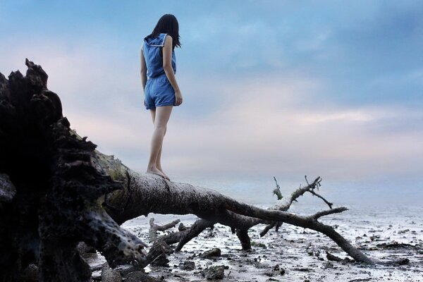 Risk. Girl on a tree by the water