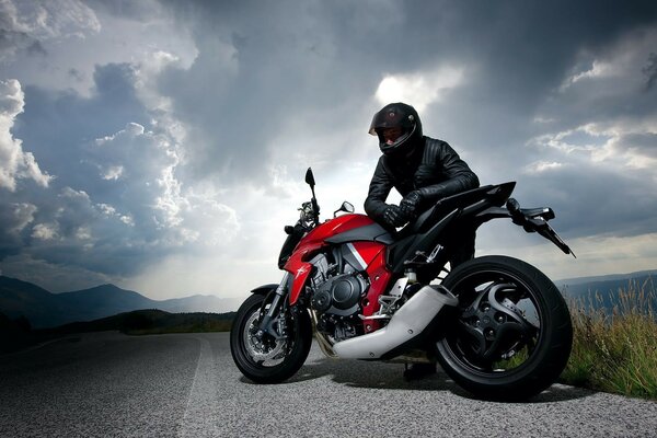 Biker mit Motorrad auf Wolken Hintergrund