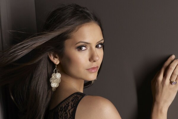 Girl with earrings on a brown background