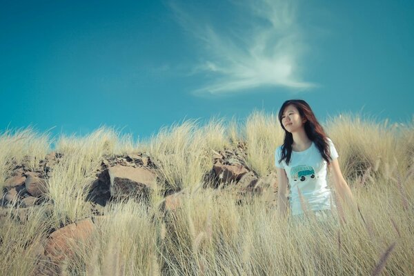 Chica en la naturaleza en las montañas de piedra en la hierba