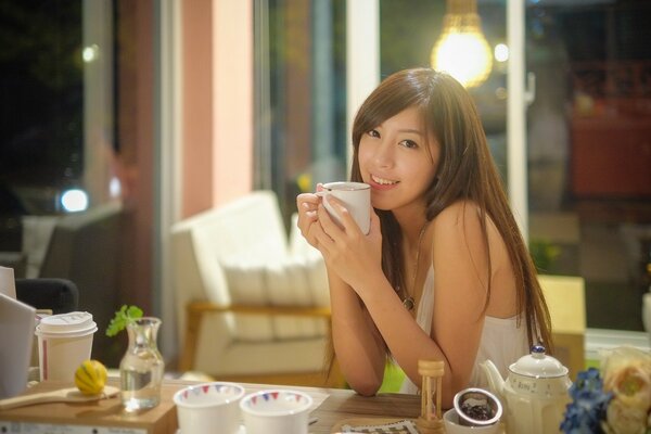 A woman drinks tea indoors