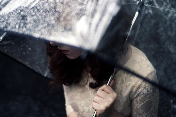 Fille solitaire sous un parapluie transparent