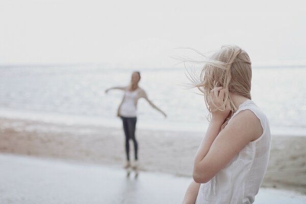 Two girls on the beach by the sea