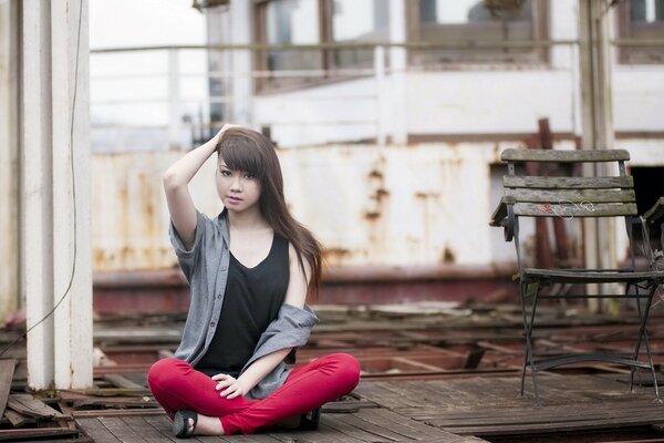 Street photo of a girl on the background of an old fence