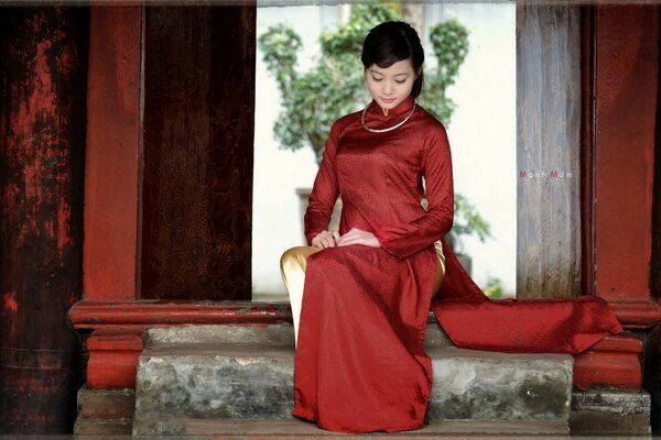 A girl on the steps in a red dress