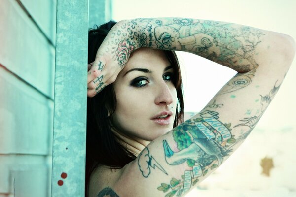 A girl with tattoos poses beautifully