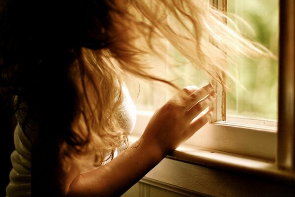 Young girl on the background of an open window