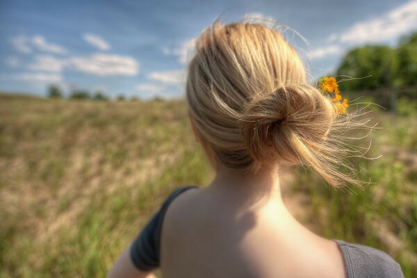 Mädchen mit Strohhaar und offenem Rücken im Sommer in der Natur