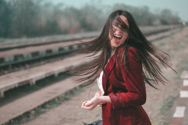 Chica delante de los rieles que conducen a la distancia