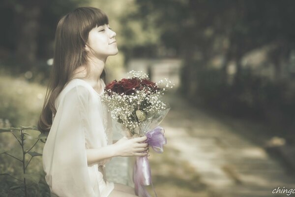 Chica en la naturaleza con un ramo de flores