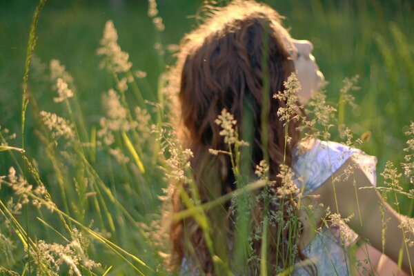 Ragazza con gli occhi chiusi nel campo