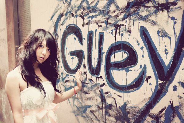 A girl in a wedding dress next to graffiti