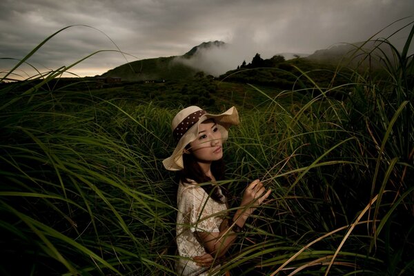 A girl in a hat in a foggy field